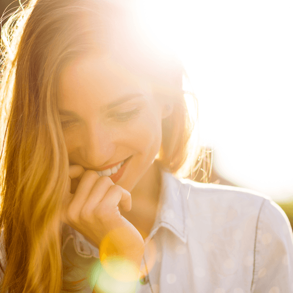 Woman smiling and looking down at ground