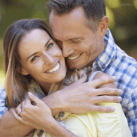 Man and woman hugging and smiling outdoors