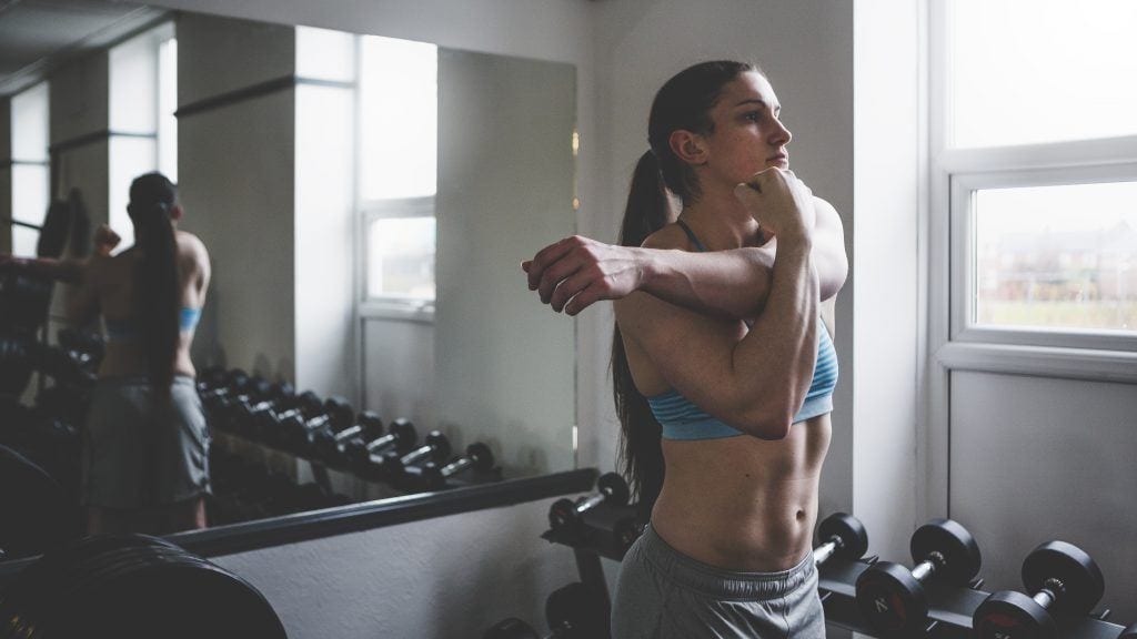 Woman stretching after a workout in the gym