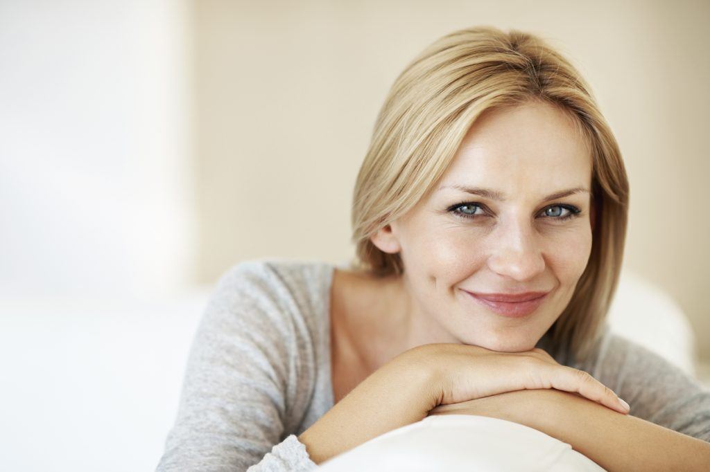 Woman smiling while sitting on couch