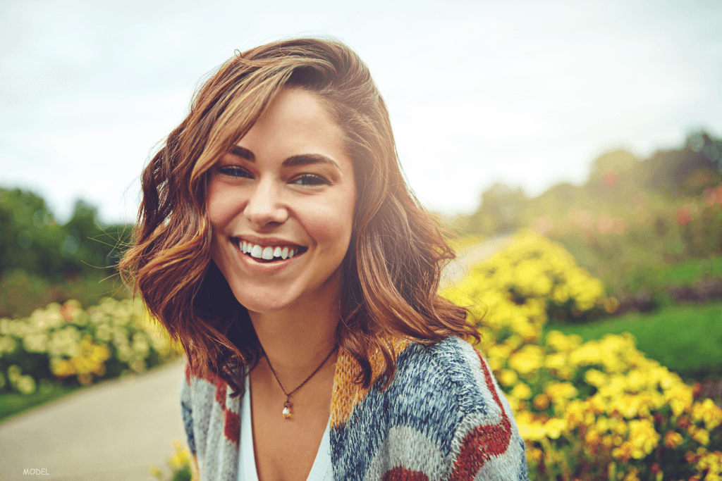 Woman smiling near yellow flowers