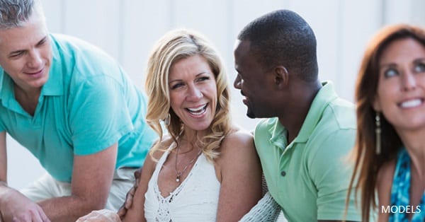 Two men and two women laughing together as they share a conversation